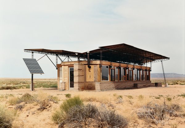 Architect Hank Louis worked with Navajo tribe elders to secure a 66-year lease on a half-acre lot in the middle of Bluf, Utah, for Rosie Joe and her children. The facade of their off the grid house is made up of exposed wood, red rammed earth, and glass.