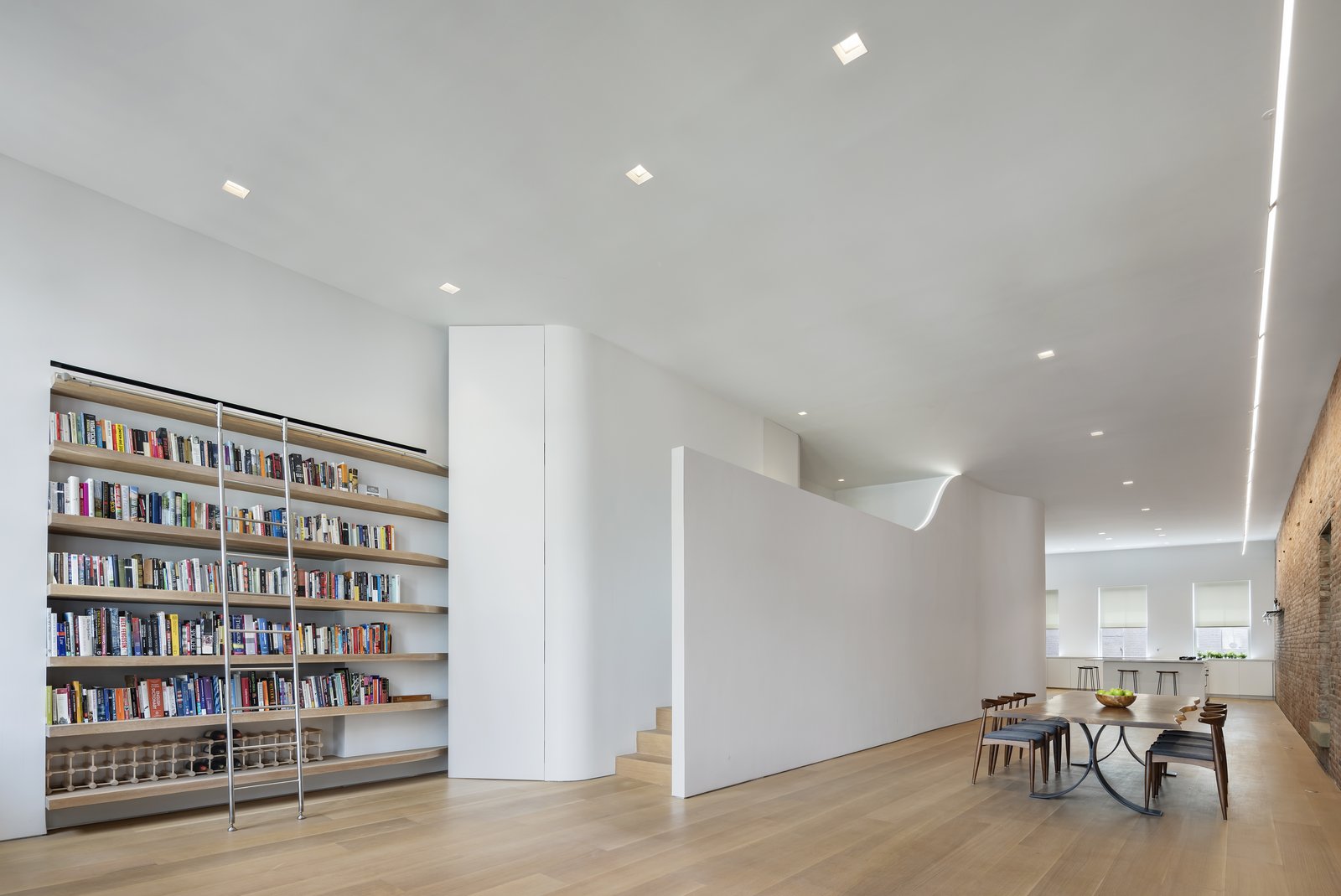 Architect Julian King’s creative approach to incorporating a bedroom without sacrificing natural light: creating a narrow mezzanine with undulating walls that act as both art and a link to the building's past as a silk warehouse.