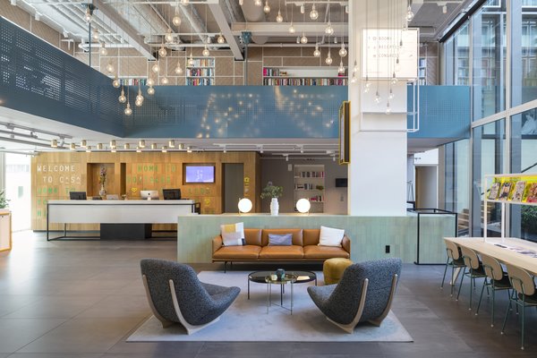 The reception desk, set against a backdrop of natural oak, creates a whimsical tone upon entry.