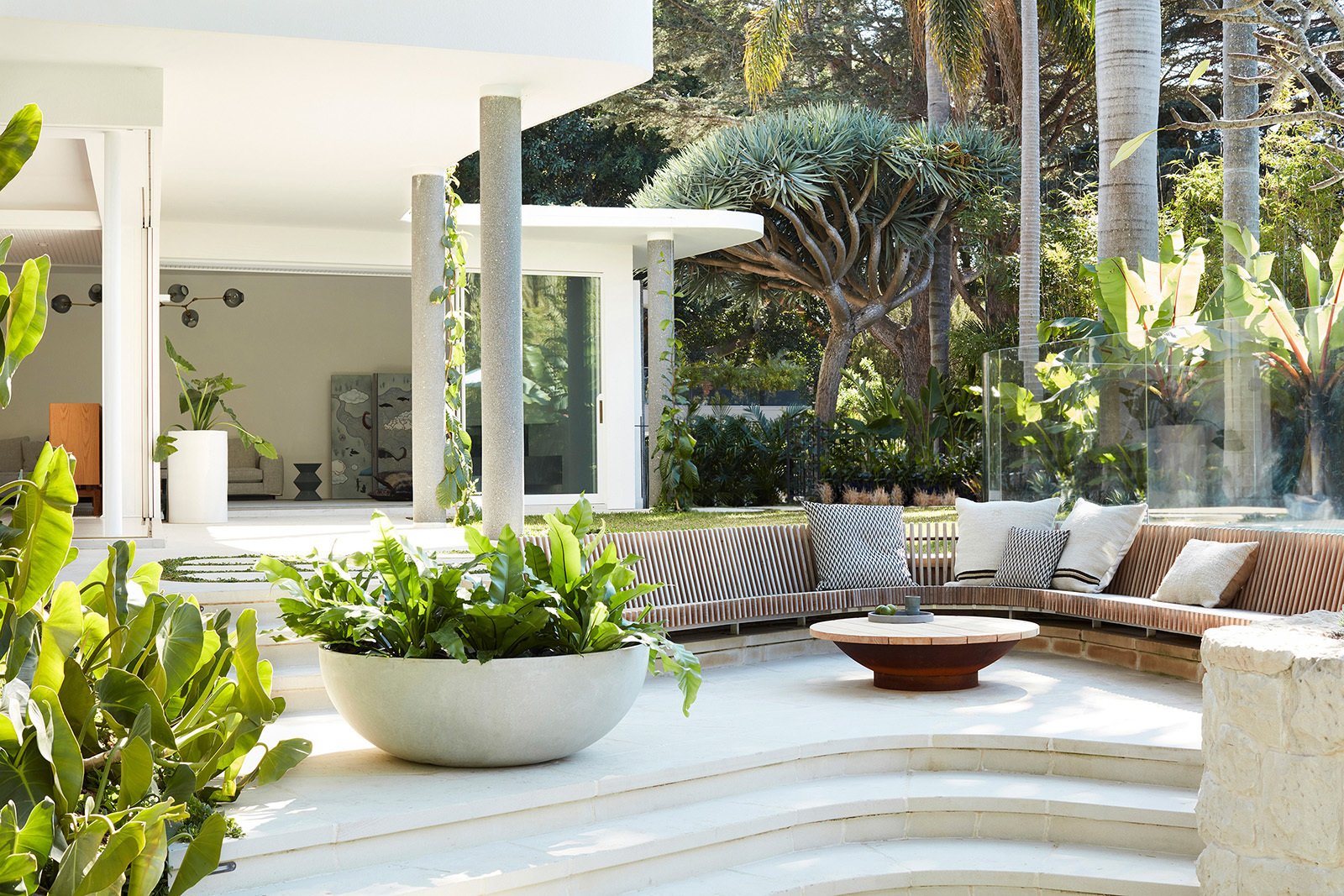 This midcentury home was originally designed by George Reeves and updated by Luigi Rosselli Architects. In the backyard, Will Dangar's landscape design places the verdant, tropical scenery at center stage.