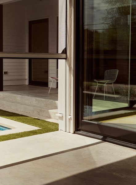 The cozy, traditional farmhouse style of this Dallas residence belies the 21st-century automated systems that power it. Among the smart-wired features is a retractable screen door by Phantom Screens. Controlled via a system called RTI (Remote Technologies Interface), it slides upward to connect the breezeway to the pool.