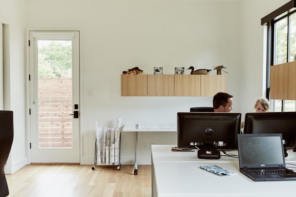 The two-story structure includes a simple office furnished with desks and cabinets by Hon Voi (below). Nearly all of the home’s 29 windows—which help keep cooling and lighting costs to a minimum—are controlled via the RTI app, which consolidates nearly a dozen apps from Lutron, Honeywell, and others.