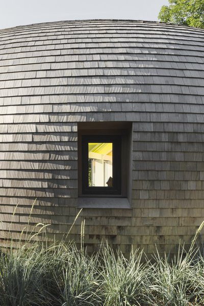 Edwards Anker clad the home in cedar shingles in a nod to the local context, as many traditional homes on Long Island use the material. "Because it's such an old craft, and cedar shingles have been around in Long Island for hundreds of years, they've developed technologies for double curving these shingles for a lot of curved shapes," says Edwards Anker.