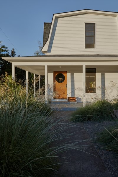 A full exterior remodel of the older house allowed Cornuelle and Tall Firs to match its siding and trim to the new ADU. They designed a front door with a circular cut-out, bringing a modern touch to the traditional entry.