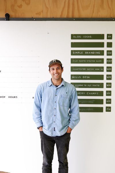George Wilkins stands in front of a green chalkboard sign system that serves as a 