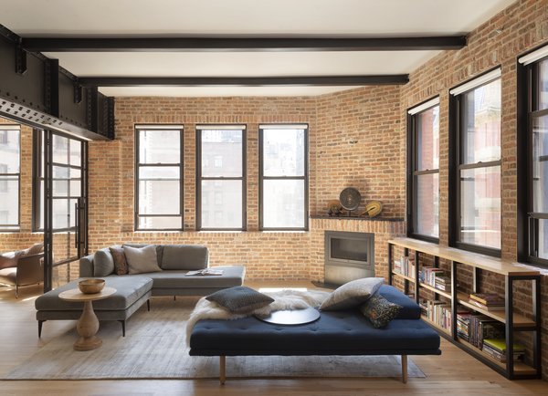 Thirteen windows in the apartment help maximize the fantastic views. The seating—including a sectional from West Elm and daybed from BoConcept—is now complemented by a fireplace specified by the firm.