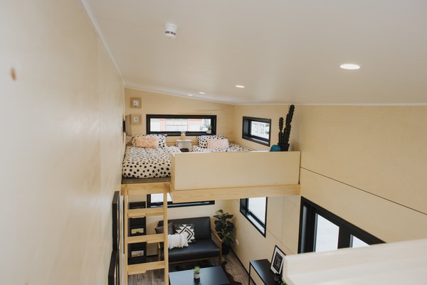 One of the loft-style bedrooms features two sizable windows, and it accommodates a set of twin beds.
