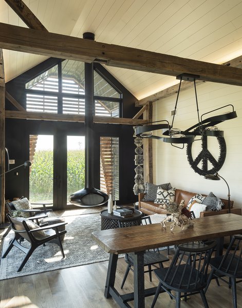 A hanging fireplace from Fireorb anchors the living area, where Book Totem and Peace Sign, both by Karen, are on display. A Graffiti pendant by Hubbardton Forge hangs over a custom table by Jed Dawson.