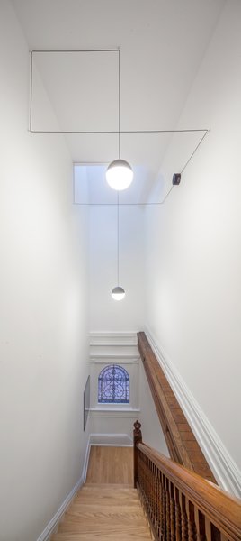 To bring natural light into the center of the home, LeBlanc inserted a thin skylight above the stairs. The chandelier is from Michael Anastassiaees. 
