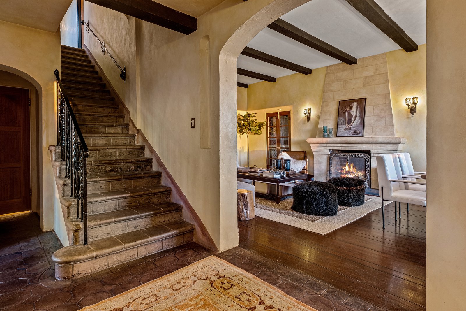 A foyer near the entry leads into the home’s main living areas—including a spacious family room, kitchen, and dining room. Original exposed beams line the ceiling throughout.