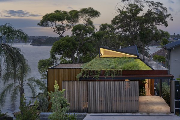 Bundeena Beach House connects the street and wider community to the water views beyond thanks to its low-lying form and a native roof garden, which the architect describes as a "green infinity edge."