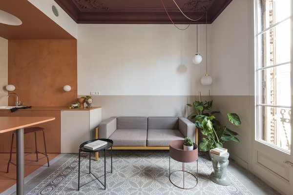 The living room post transformation has a Kettal Landscape sofa with mustard frame and mink cushions, a planter by FermLiving, and a Handvärk lamp by Studio Floor. 