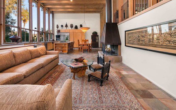 The formal living area features slate tile floors and an original copper-topped fireplace. The large area seamlessly flows into the kitchen and dining room.