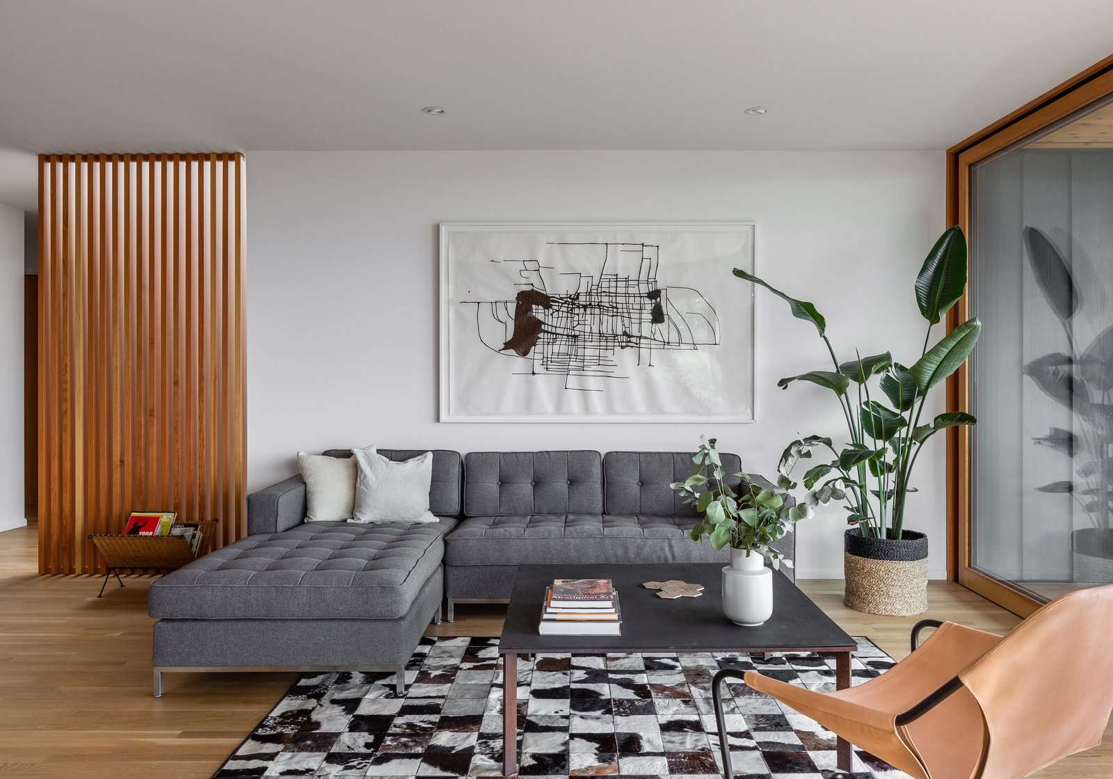 Now, the furniture grouping comfortably occupies the room. A sectional from Gus Modern sits with a custom steel coffee table and Paulistano Armchair.
