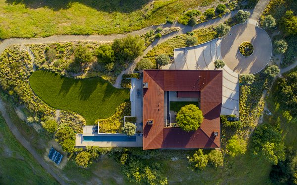 Punctuated by a central courtyard, the single-story residence was designed as a grid of 25-foot squares. Fisher selected corrugated Cor-ten steel for the facade and roof, all of which has since 'aged' to create a rich, earthy color that blends into the 19-plus acre property.