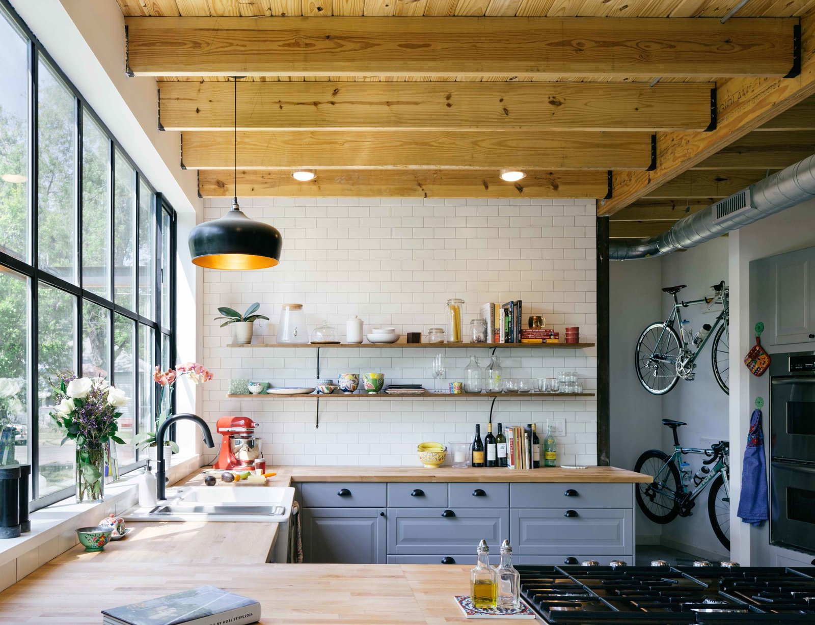 Shane Michael Pavonetti, an Austin-based architect and contractor, and his wife, Holly, built their eco-friendly home on a lean budget of $175,000. The cedar siding used on the exterior reappears throughout the house. Keen on recycling the wood, the couple added shelving to their kitchen as well. 