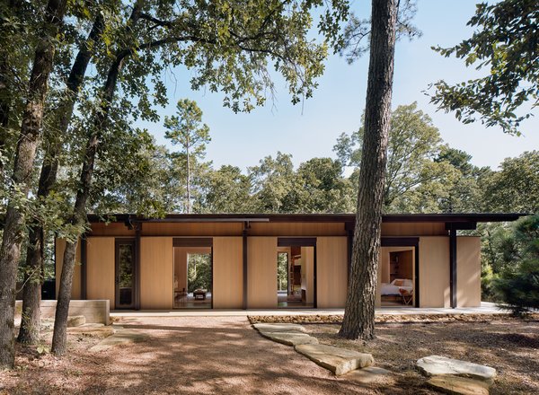 The interior spaces feature large, sliding glass pocket doors on opposite sides of each room that provide generous views of the surrounding forest and lake, and promote cross-ventilation from prevailing breezes from the southeast.