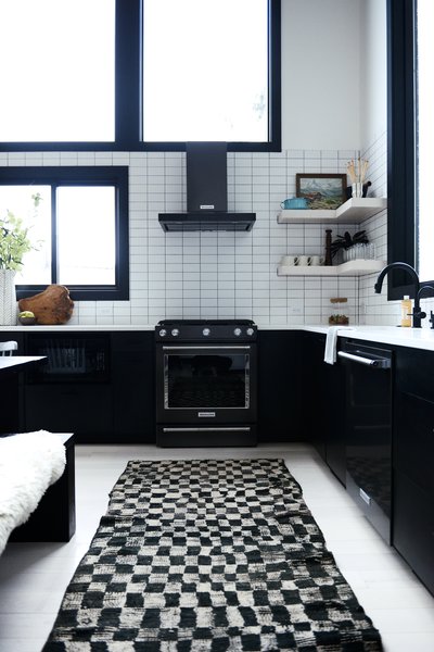 "In my Alpine Noir project, we used laminate kitchen cabinets because of the ease of maintenance and cost savings," explains interior designer Casey Keasler of Casework. The vintage Moroccan checkerboard runner is from Kat + Maouche.
