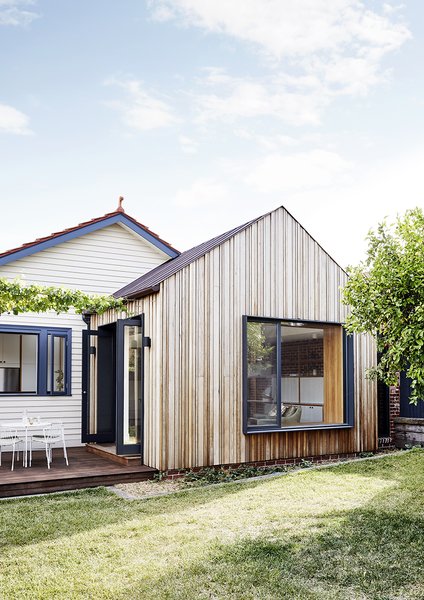 The new addition, only visible from the backyard, echoes the gabled form of the original home. Large openings connect the main living spaces with the backyard.