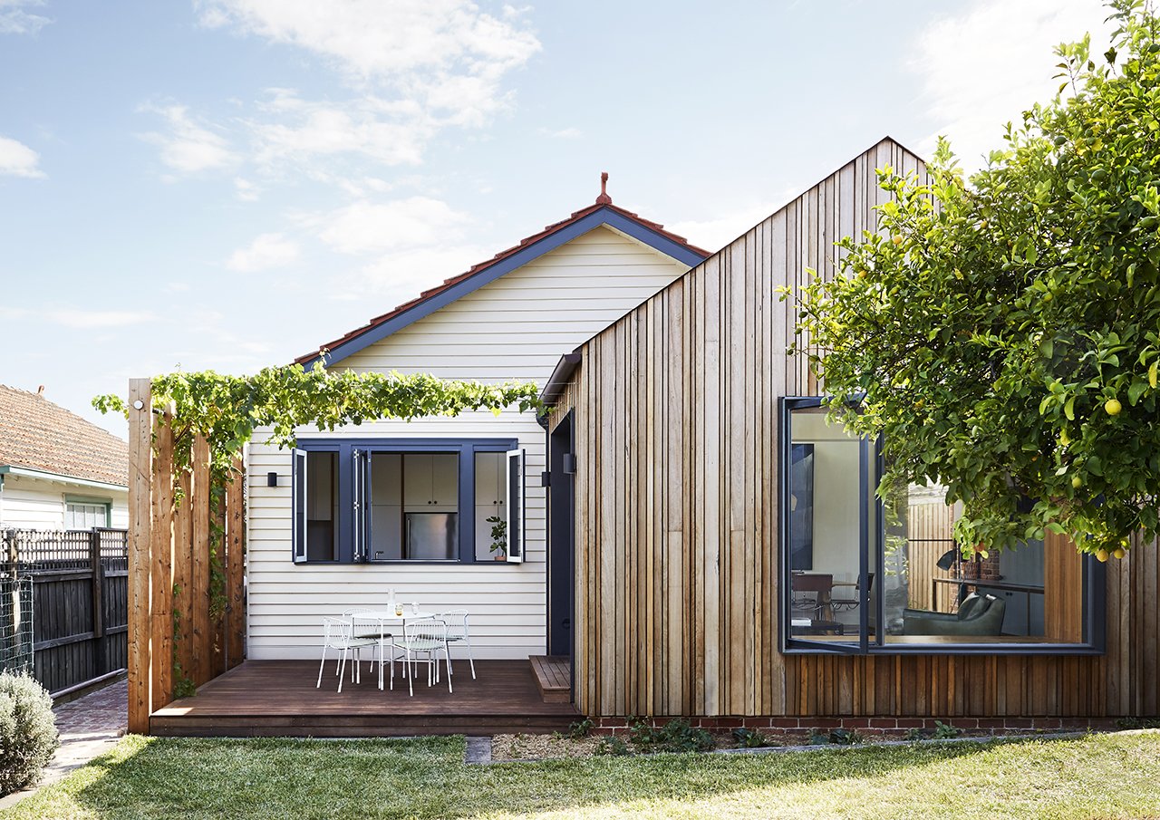 The addition is clad in timber boards of various widths and depths, adding a subtle layer of texture to the simple, gabled form.