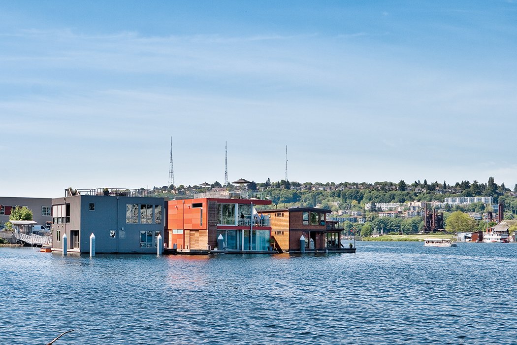 This colorful floating home eschews maritime themes in favor of a clean and contemporary aesthetic. The interior pulls in views of Lake Union through floor-to-ceiling windows. 