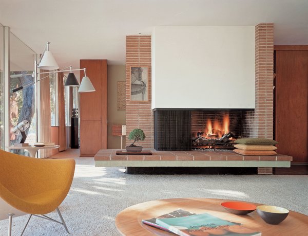 <font face="Theinhardt, -apple-system, BlinkMacSystemFont, Segoe UI, Roboto, Oxygen-Sans, Ubuntu, Cantarell, Helvetica Neue, sans-serif">A brick fireplace divides several spaces and sightlines within the otherwise open-concept floor plan. In the background, floor-to-ceiling </font>mahogany<font face="Theinhardt, -apple-system, BlinkMacSystemFont, Segoe UI, Roboto, Oxygen-Sans, Ubuntu, Cantarell, Helvetica Neue, sans-serif"> cabinetry creates privacy and a transition along the hallway into the master suite.</font>