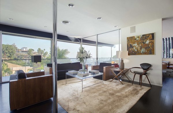 The home's top level features a dramatic living room that opens onto a cantilevering balcony. Now available as a monthly rental, the Lew House comes fully furnished with pieces by mid-century design icons such as Kagan, Baughman, Robsjohn-Gibbings, Cherner, and Sciolari.