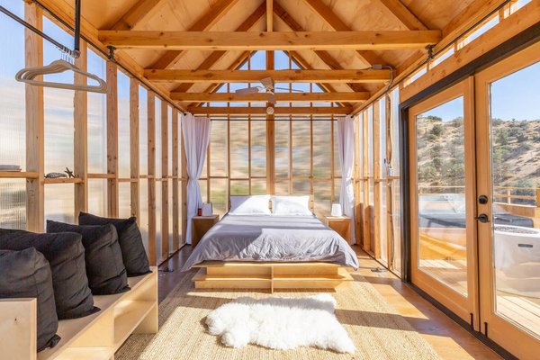 The walls of this contemporary one-room cabin are covered in insulating polycarbonate siding.