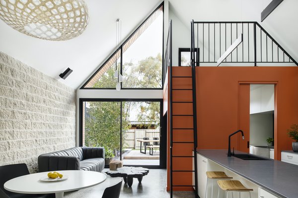 The mezzanine above the laundry will eventually be used as a study. The orange joinery beneath it functions as part of the entertainment unit and as storage for wine glasses.