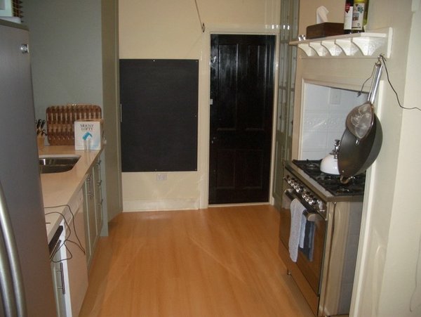 Before: The sink had a window, which was bordered on either side by tall, columnar units—including storage spaces and the refrigerator.