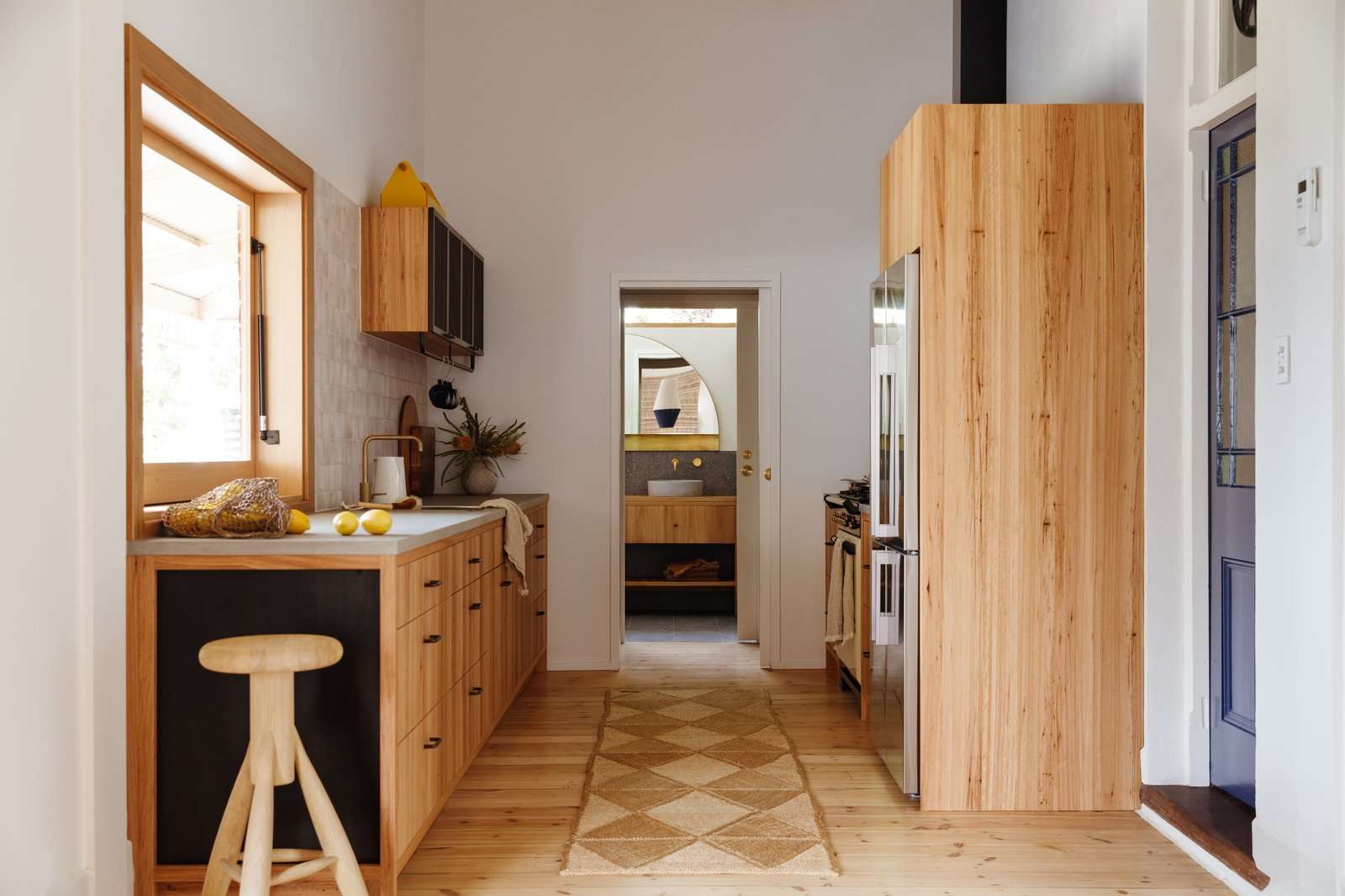 Harry wove a tactile palette of earthy tones throughout the new space, which includes blackbutt cabinetry, cement counters, and handmade backsplash tile from Spain.