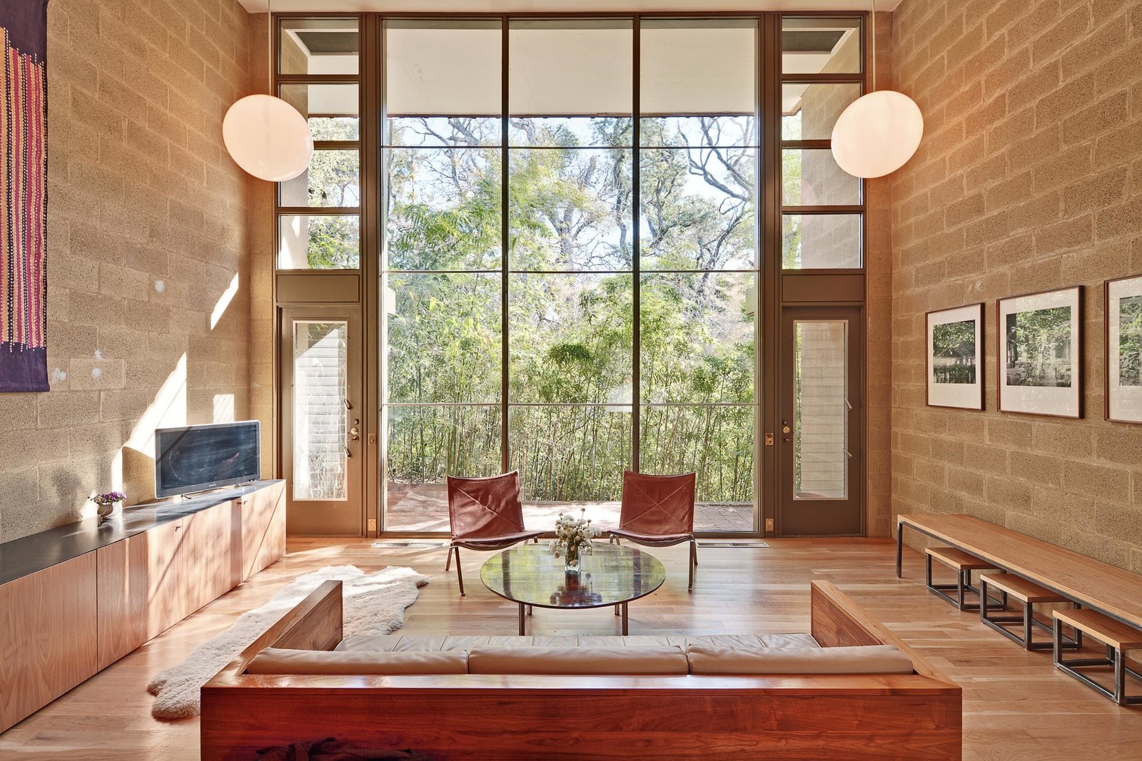 The star of each unit is the double-height living room, featuring a dramatic wall of windows framed by exposed masonry block walls. Shown here, Unit No 3. was restored several years ago by Ernesto Cragnolino of Alterstudio and Krista Whitson of Mel Lawrence Architects, who used the apartment as their personal residence.