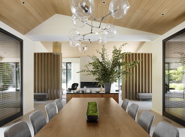 The dining room features custom wooden room dividers designed by ODADA, a Jason Gaidmore table, a Lindsey Adelman pendant light, and a Jason Giuntoli Custom Furniture credenza. 