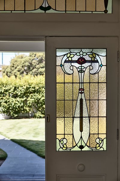 In the front of the home, original Edwardian details remain—including the stained glass doors and window. The large front yard remains as a play area for the children.