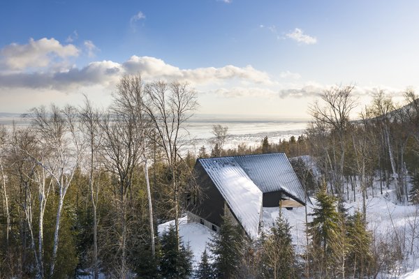 Cabin A by Bourgeois / Lechasseur architectes is perched on the mountainside overlooking the Saint Lawrence River in Québec, Canada. The "A" in the name references the nautical alphabet of the International Code of Signals (ICS), while the home's angular form was derived from the maritime Alfa signal flag and the shape of a ship's sail facing the wind.