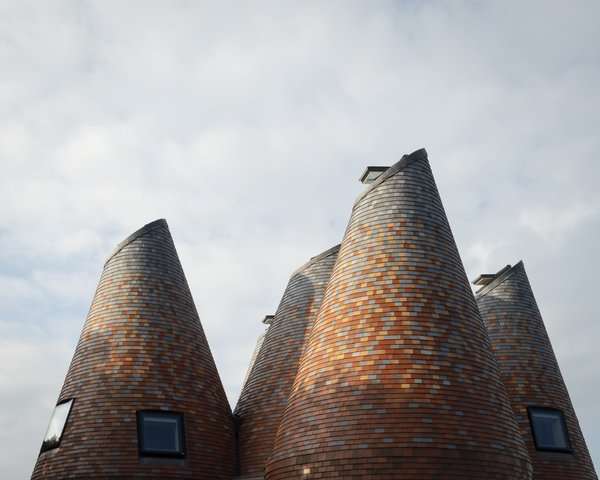 five-tile-clad-towers-forge-a-fantastical-home-inspired-by-hop-kilns