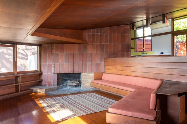 The living area is divided from the kitchen by a series of steps and a redwood-clad parapet that also forms the back of a built-in sofa. Lautner added over 25 feet of built-ins to provide storage throughout the 1,244-square-foot home.