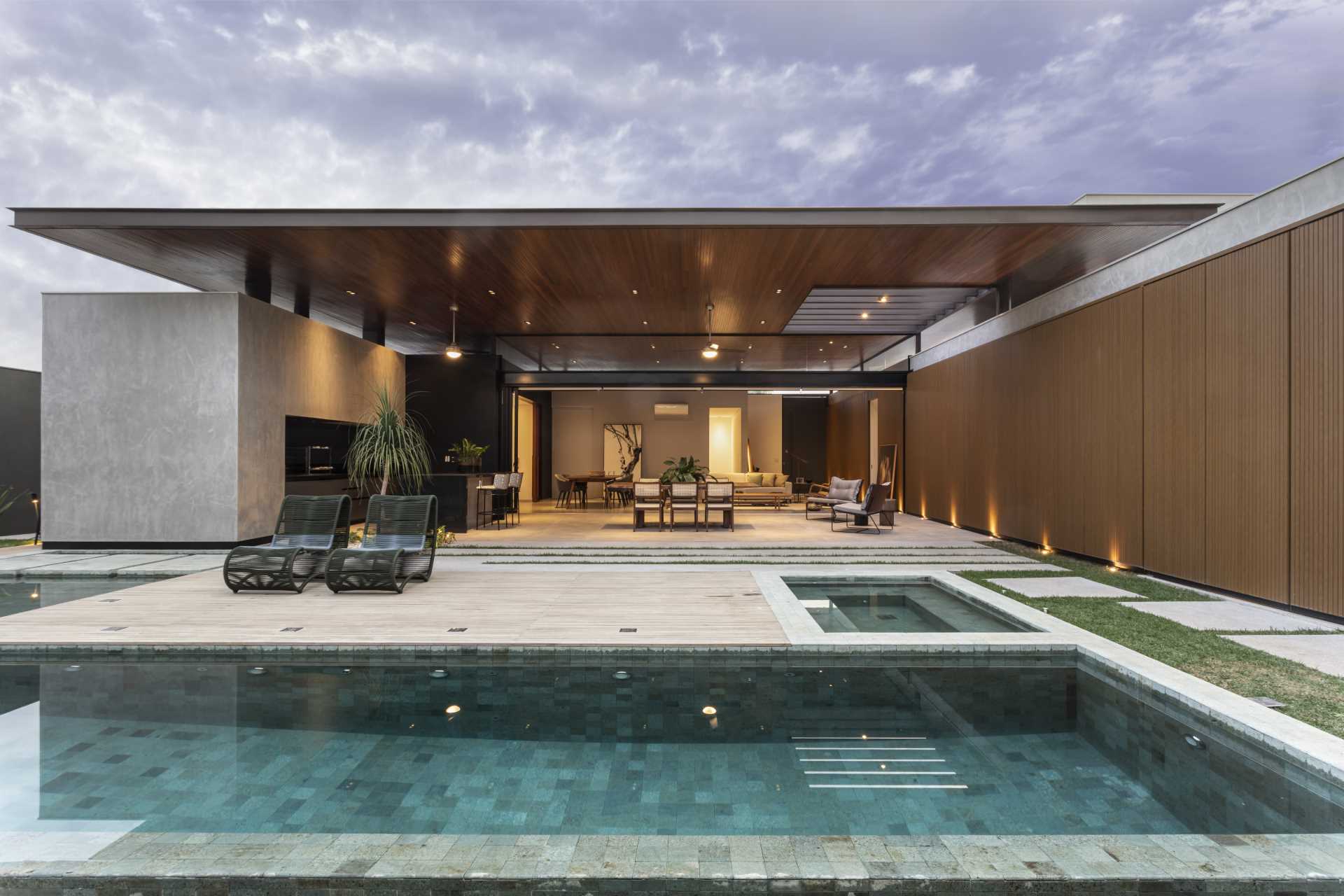 A modern house with a large double-height ceiling that covers both the interior and exterior spaces.