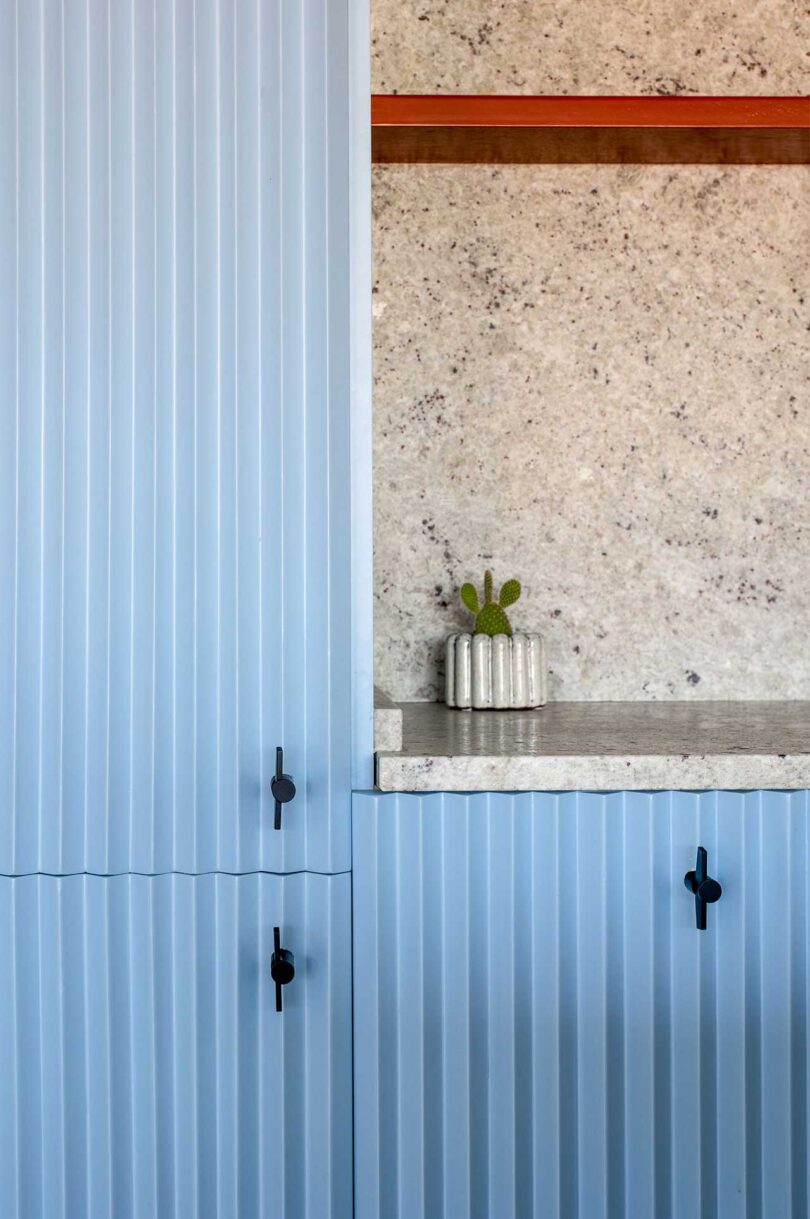 Closeup partial view of modern light blue kitchen with concrete details