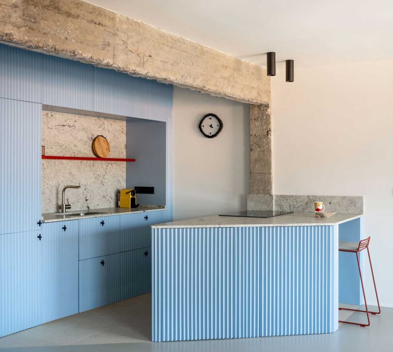 angled view of modern light blue kitchen with concrete details