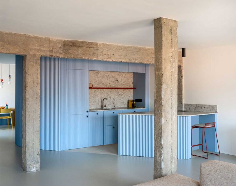 angled view of modern light blue kitchen with concrete details