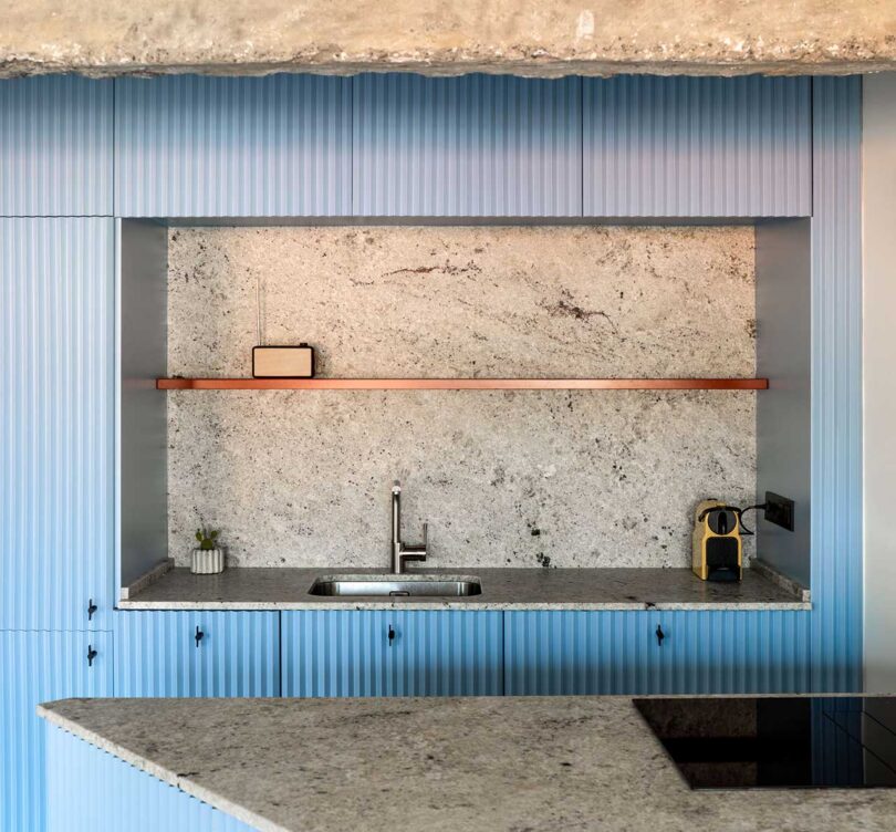 Closeup partial view of modern light blue Kitchen with concrete details