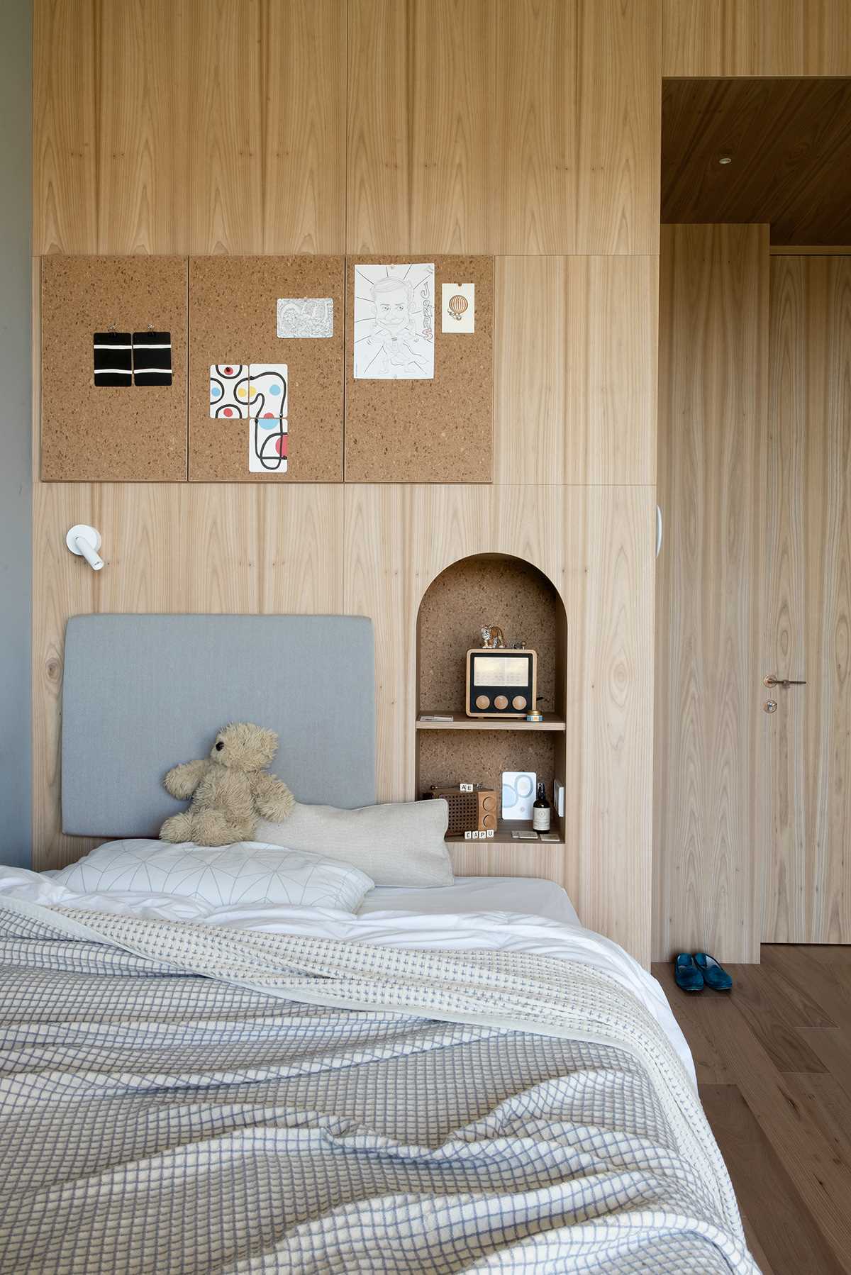 In a kid's bedroom, a small niche with a shelf acts as a bedside table.