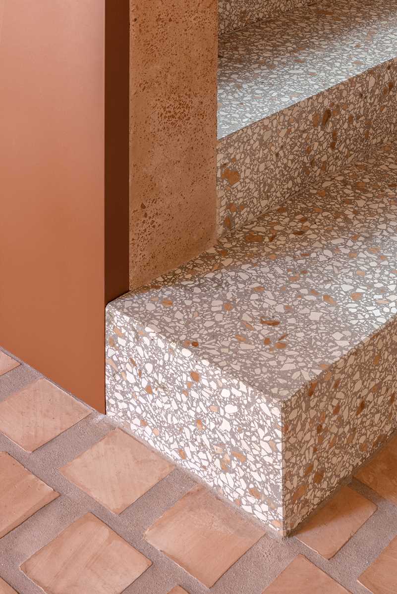 The lower level of this home features terrazzo stair treads, while the clay of the square cotto tiles has been used as aggregates mixed in the thick, lime-based plasterwork of the walls.