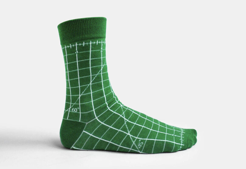 Green mid-length socks with cutting mat grid design printed across it.