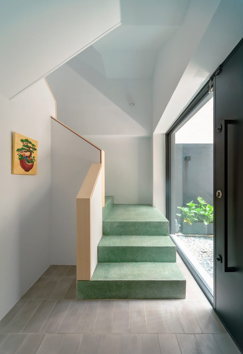 White stairwell with green staircase inside Veil House