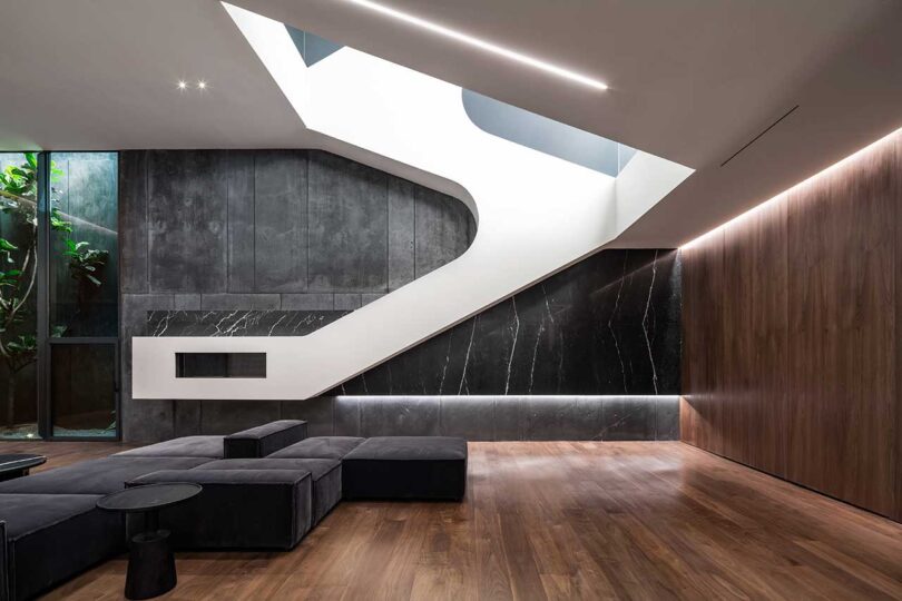 interior view of modern futuristic living room with large black modular sofa