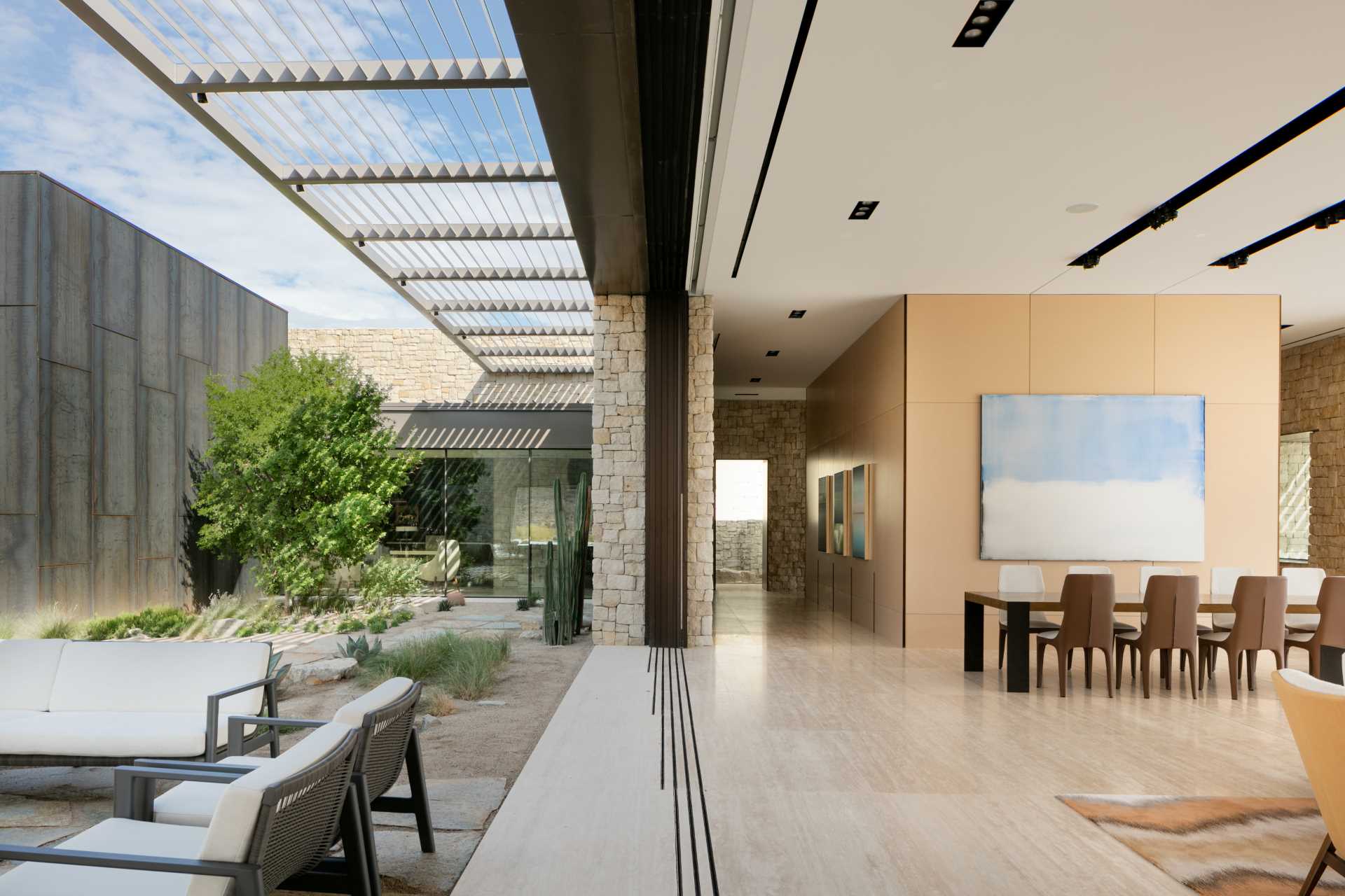 A modern living room and dining area that opens up to a private courtyard.