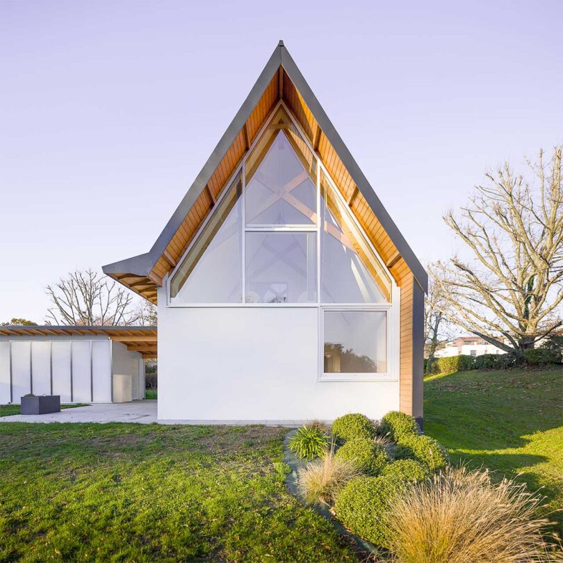 partial exterior view of modern a-frame house made of wood and white material