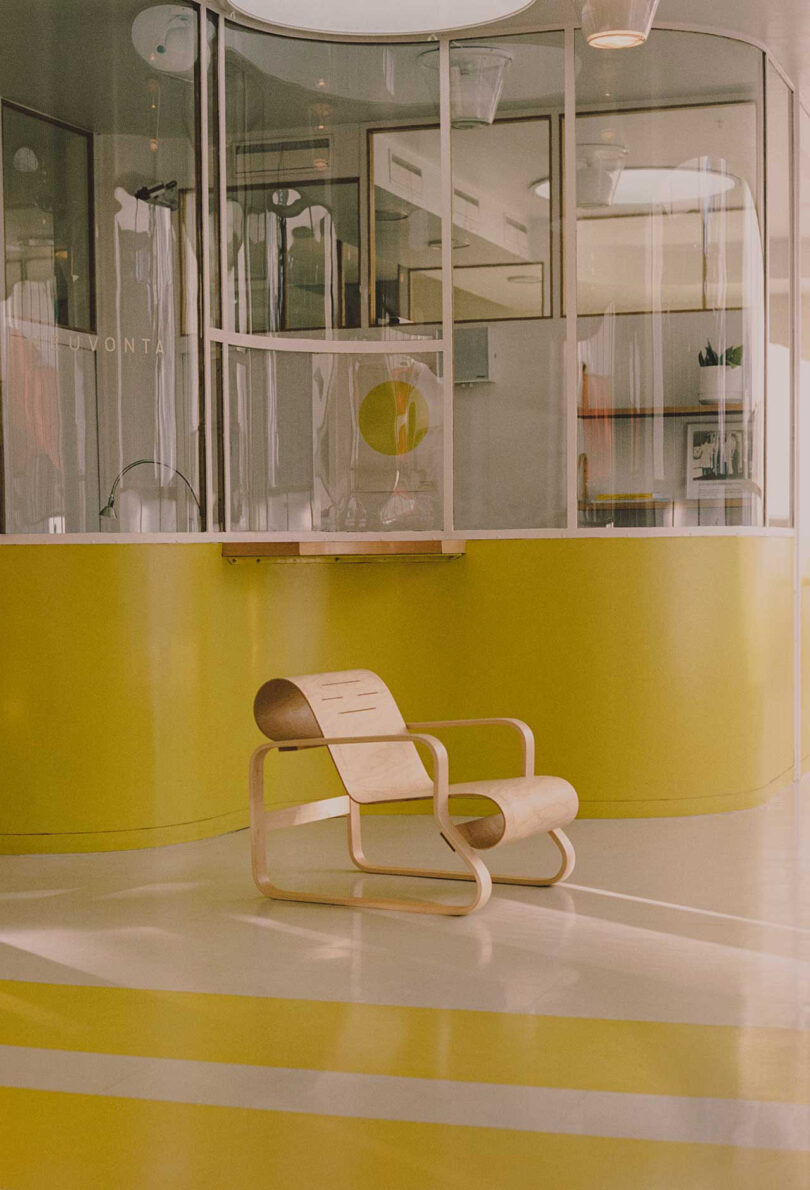 bentwood armchair in front of neon yellow and white reception area behind glass